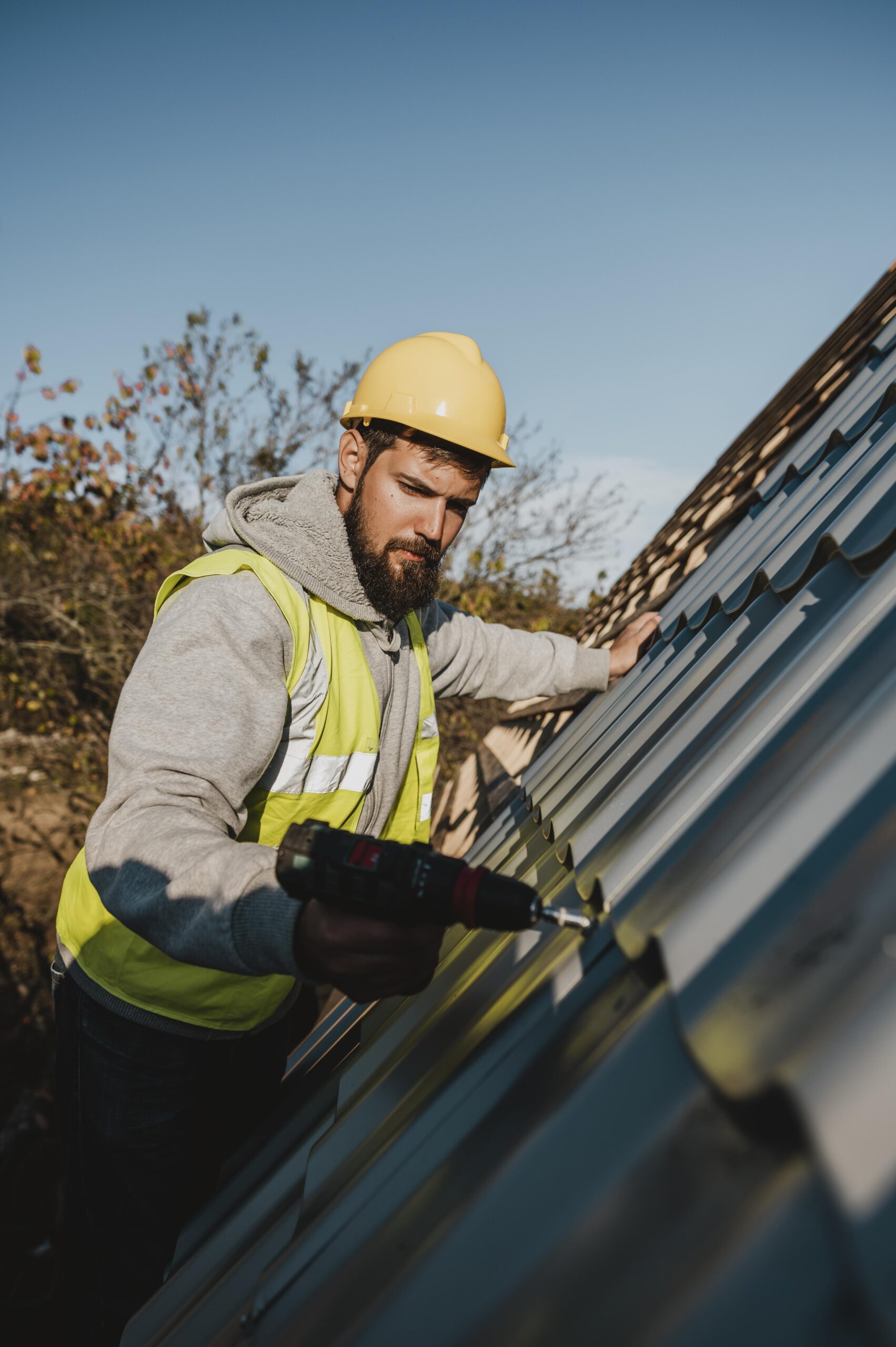 man working roof with drill scaled