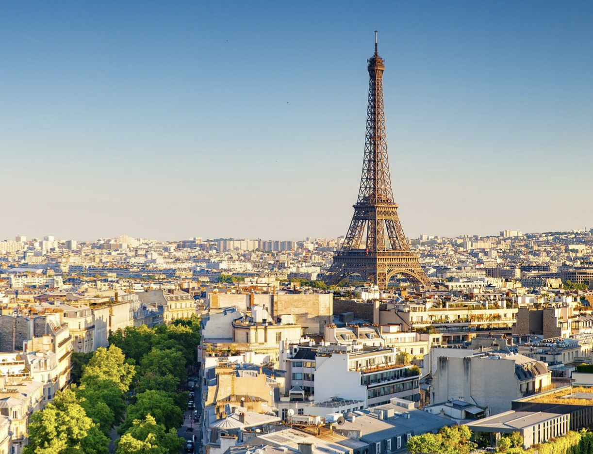 Vue aérienne de Paris avec la tour Eiffel dominant les toits haussmanniens par ciel bleu dégagé